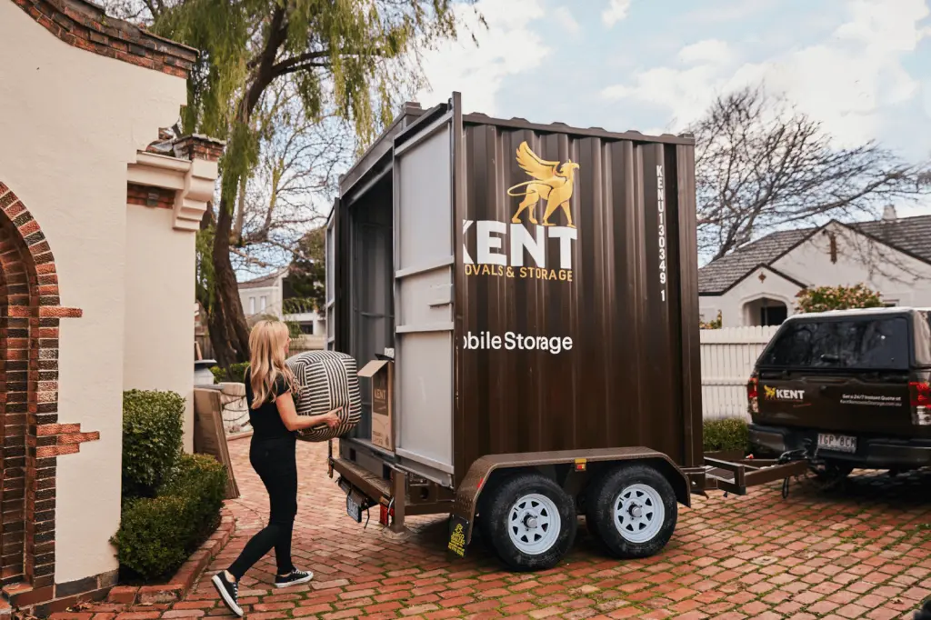 Customer loading household items into Kent Removals & Storage mobile storage container outside home
