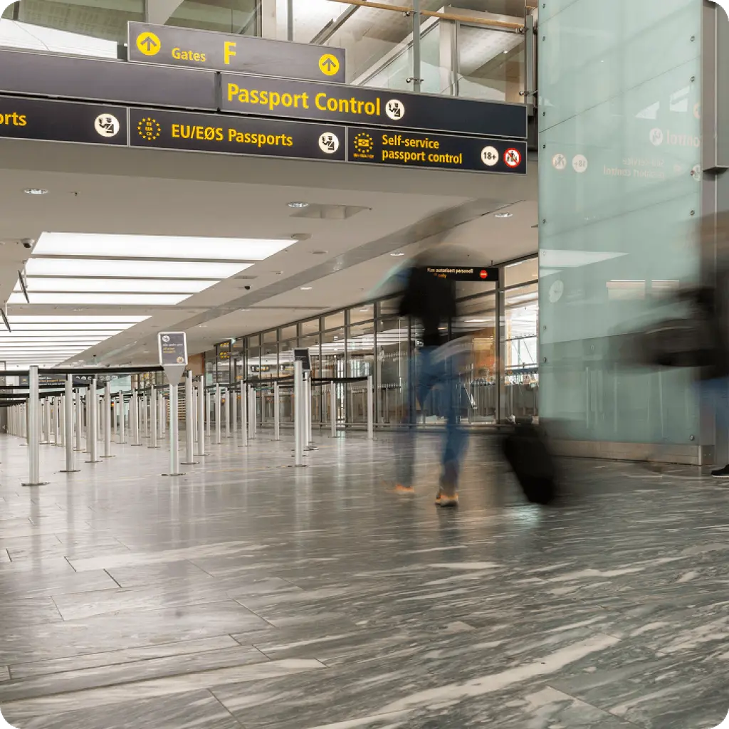 Traveller walking through airport passport control area with luggage