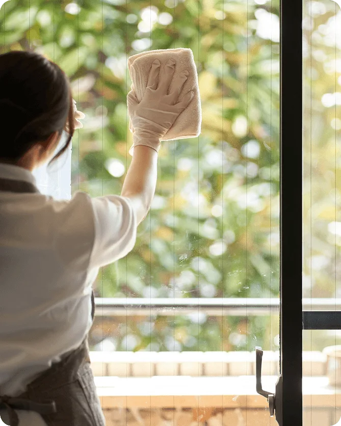Cleaner wiping glass window with cloth and gloves