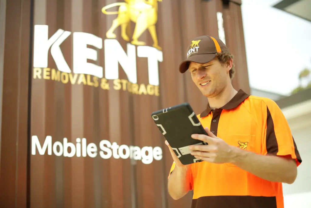Kent Removals staff member checking tablet in front of mobile storage container