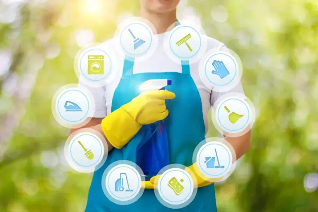 Person in apron holding spray bottle with cleaning icons