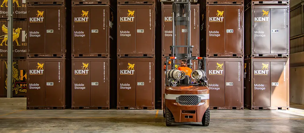 Forklift moving Kent mobile storage containers inside secure warehouse