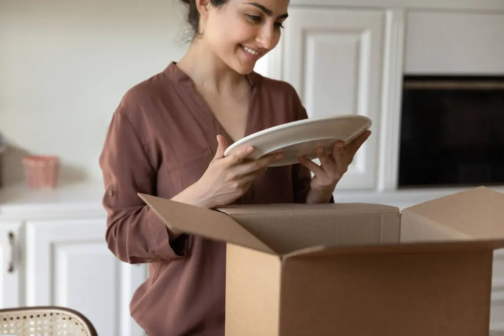 Happy woman moving to a new home and unpack some stuffs