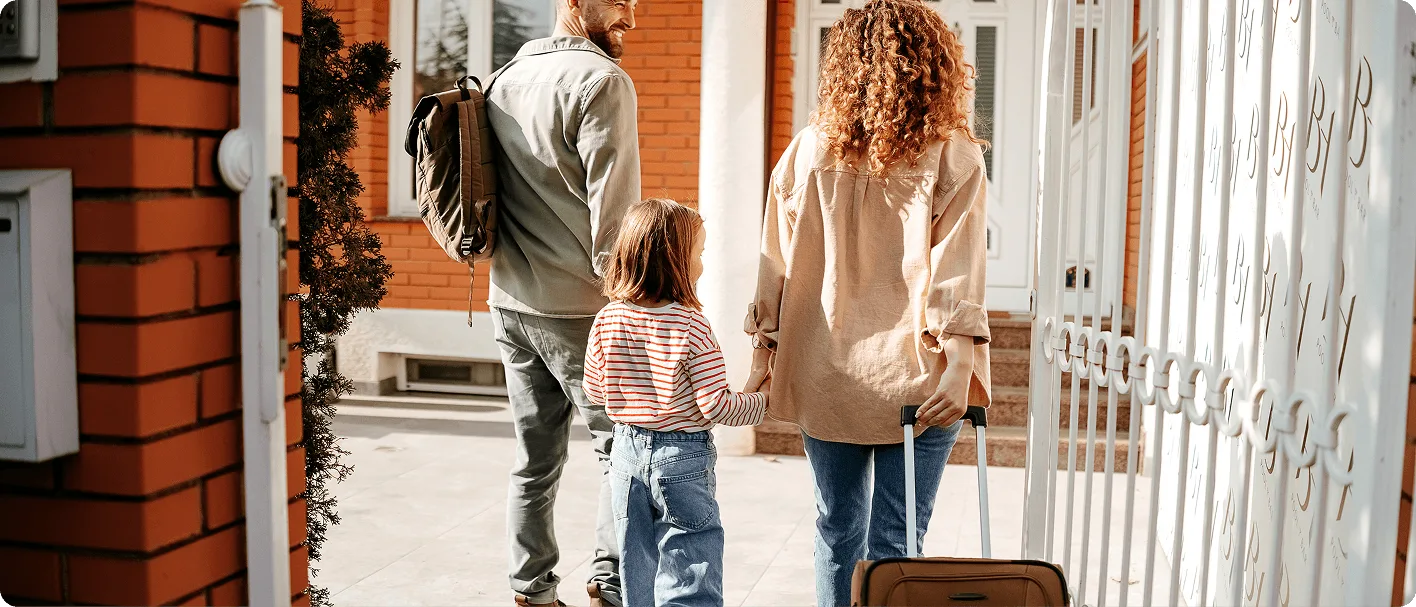 Family entering new home with luggage during house relocation