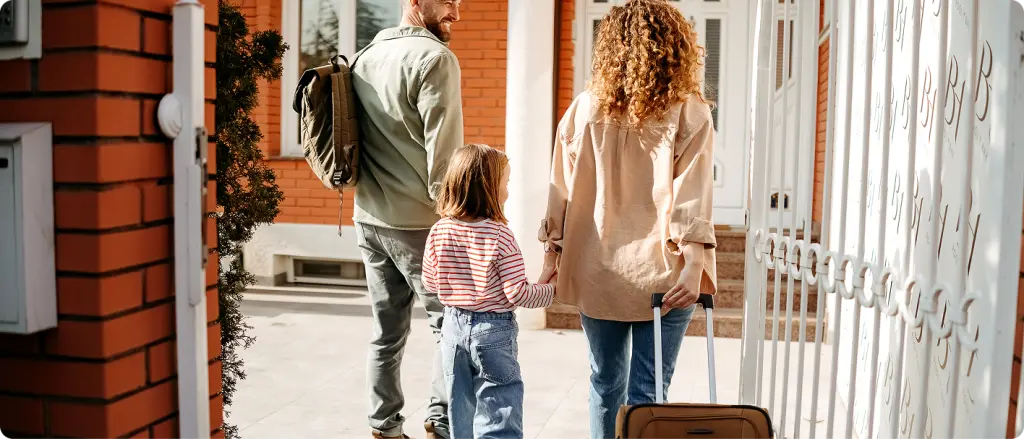 Family entering new home with luggage during house relocation
