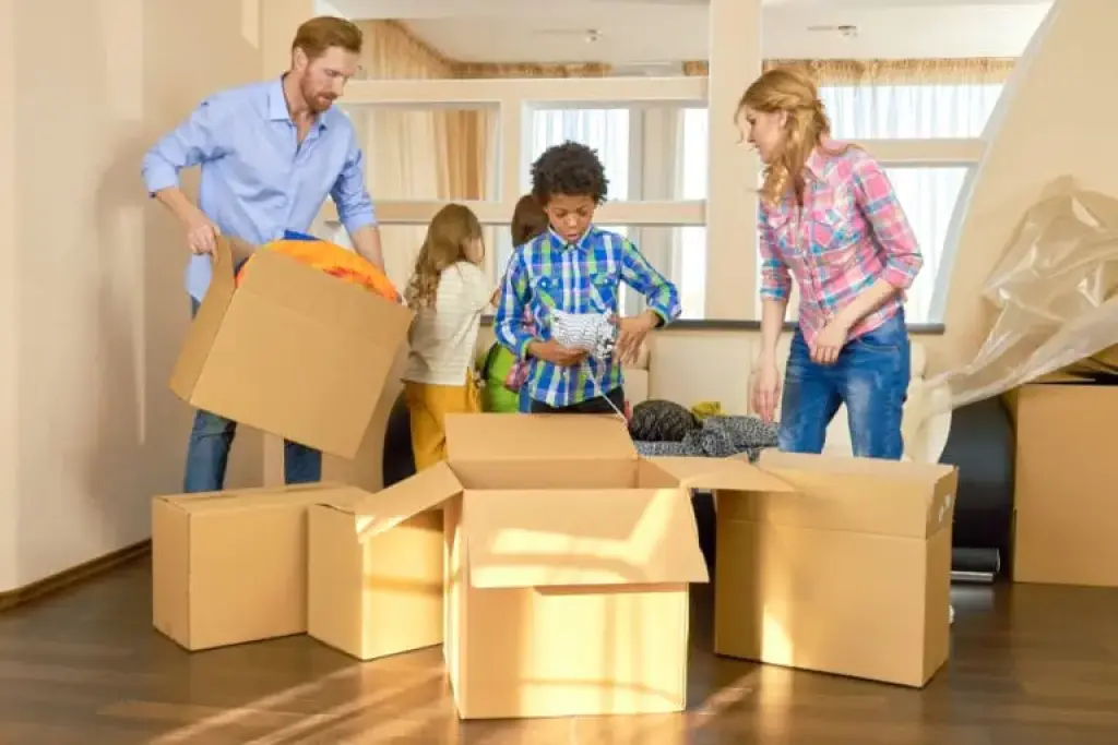 Family packing boxes while moving into new home
