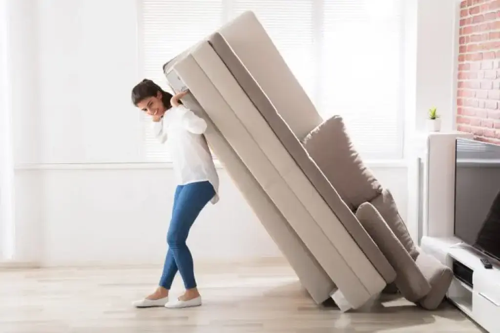 Woman carrying sofa during home move