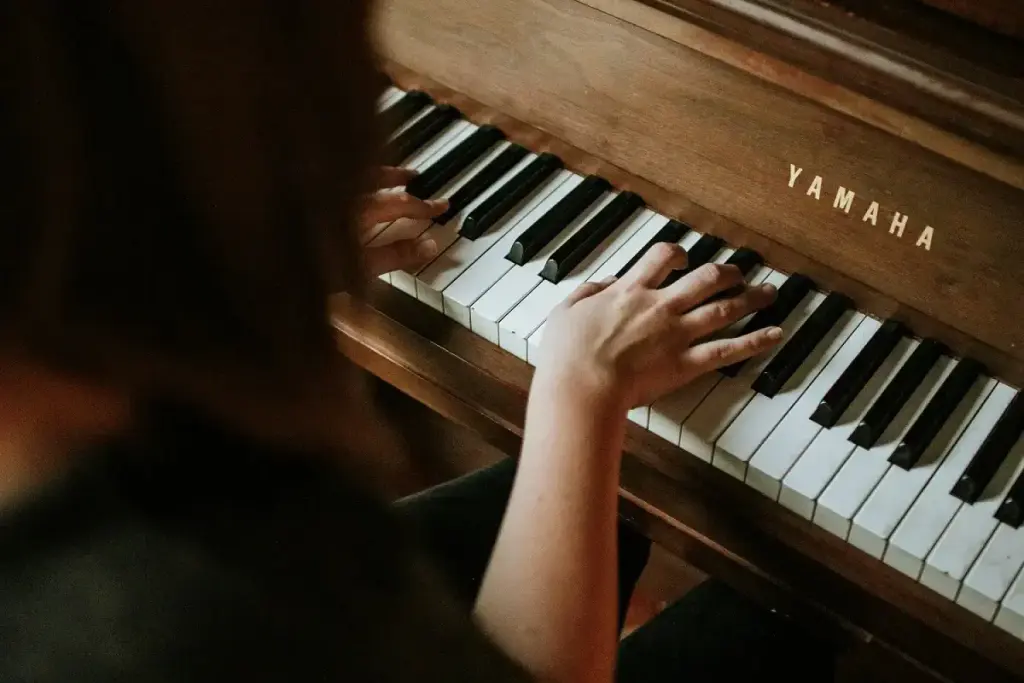 Person playing a Yamaha upright piano