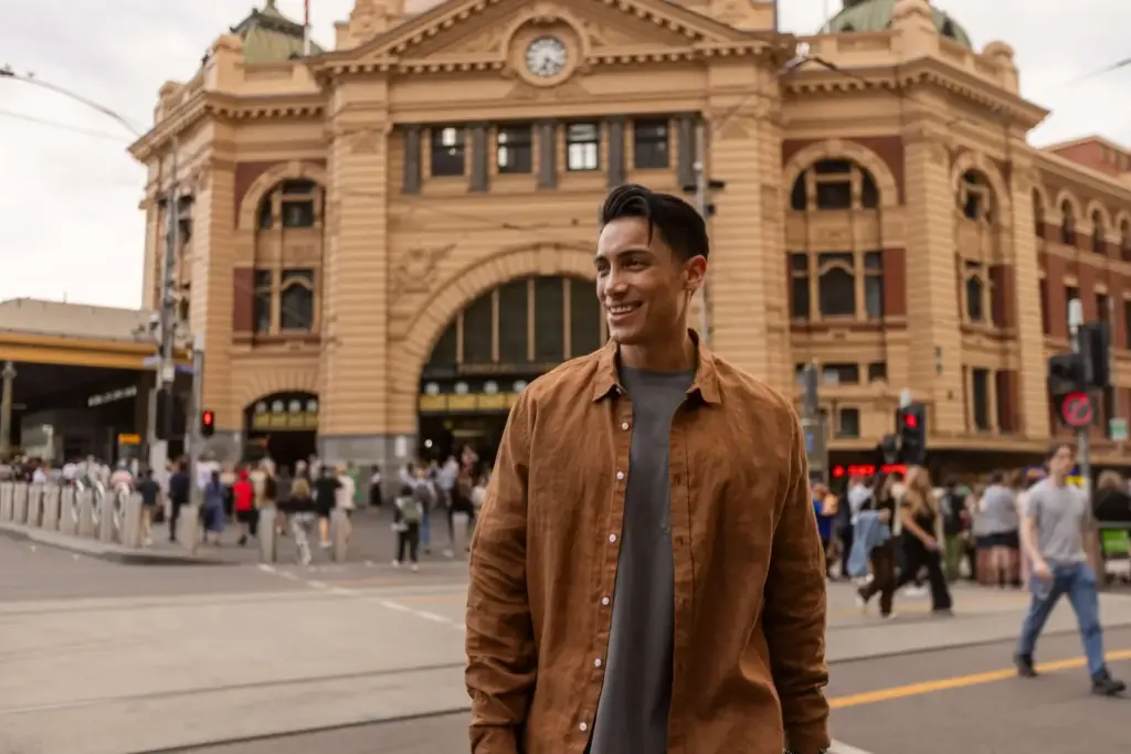 Smiling man standing in front of Flinders Street Station in Melbourne