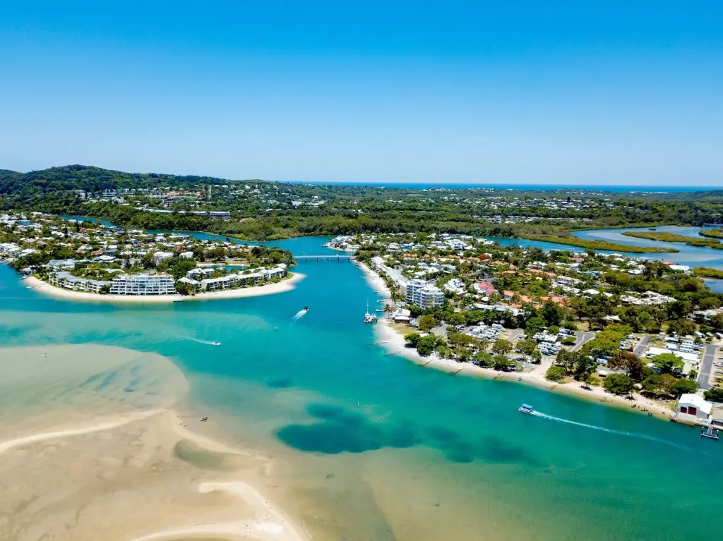 Aerial view of Noosa Heads river mouth, sandy beach, and coastal town