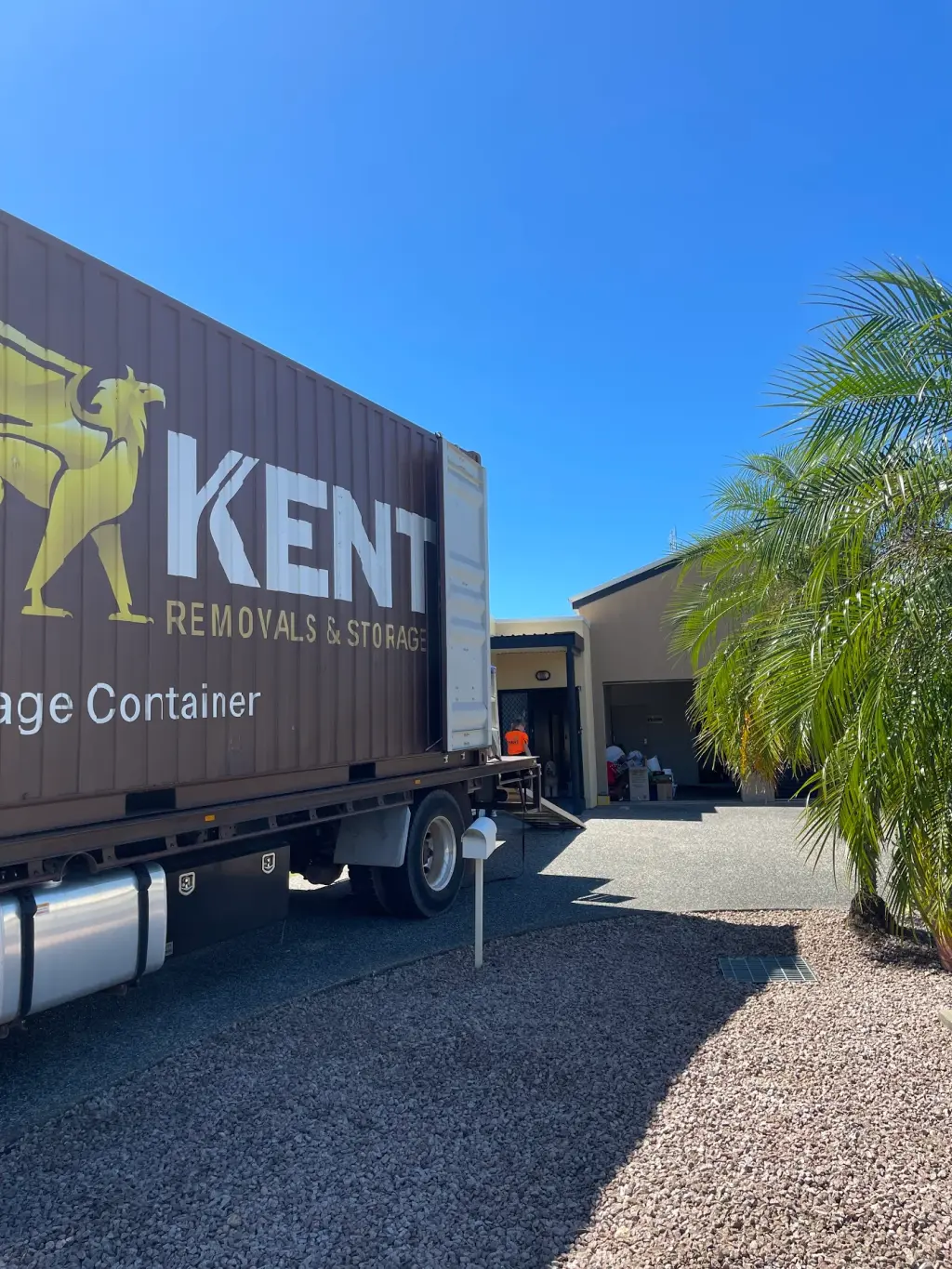 Kent Removals truck delivering storage container to residential home driveway