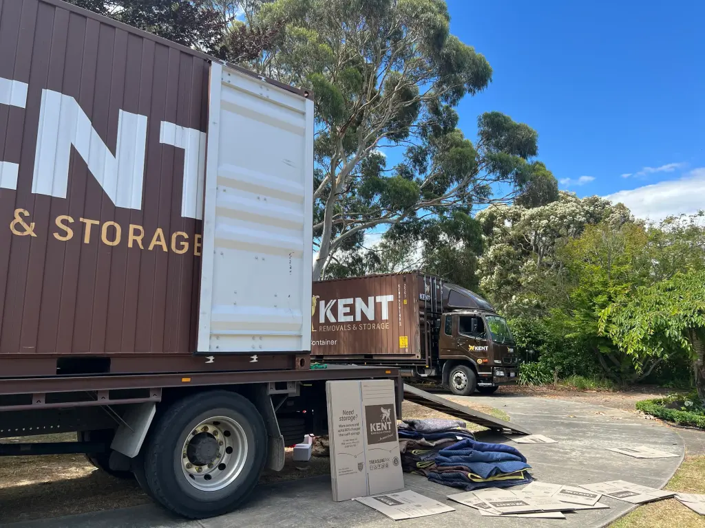 Kent Removals truck unloading storage container and moving supplies at residential home
